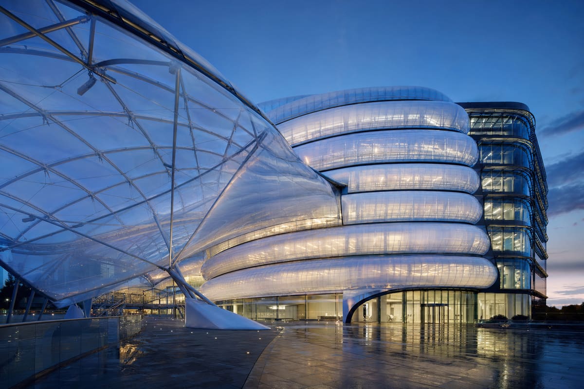 Modern ETFE commercial headquarters building at golden hour