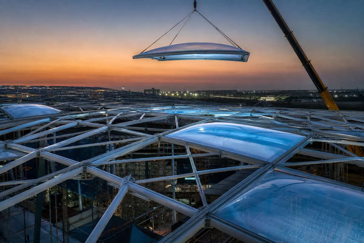 Site installation of translucent ETFE cushion modules on a large-span steel roof grid
