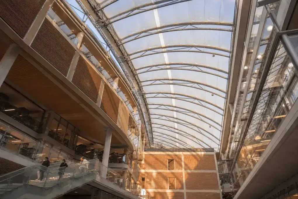 Interior looking up at a daylit ETFE cushion roof in a modern college campus with ETFE roof