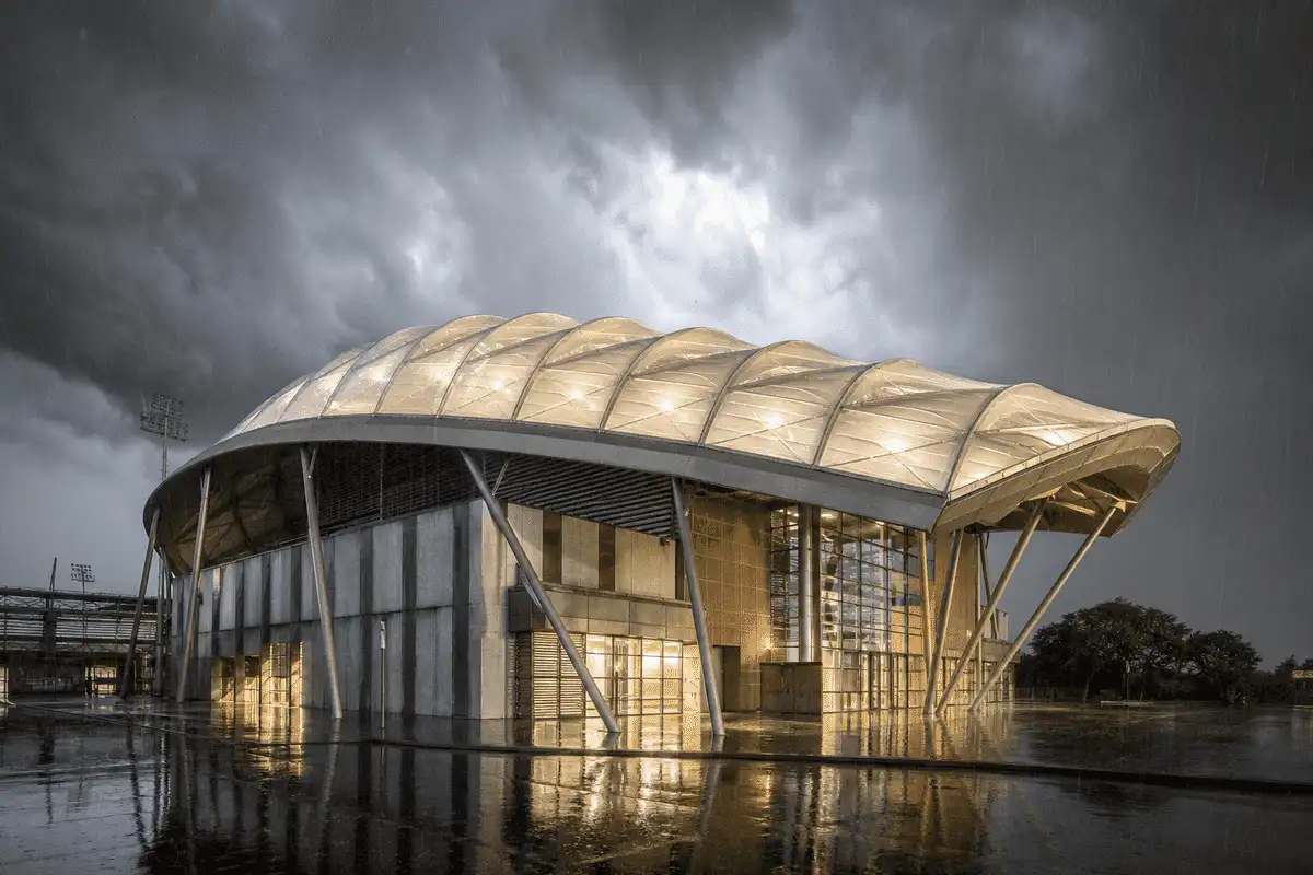 ETFE roof on an indoor sports arena bowl under dramatic storm lighting and rain — Indoor Sports Arena ETFE Roofing systems