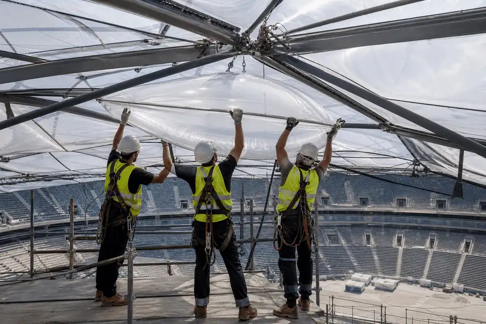 Construction crew installing ETFE cushion modules on a arena roof grid — Indoor Sports Arena ETFE Roofing systems