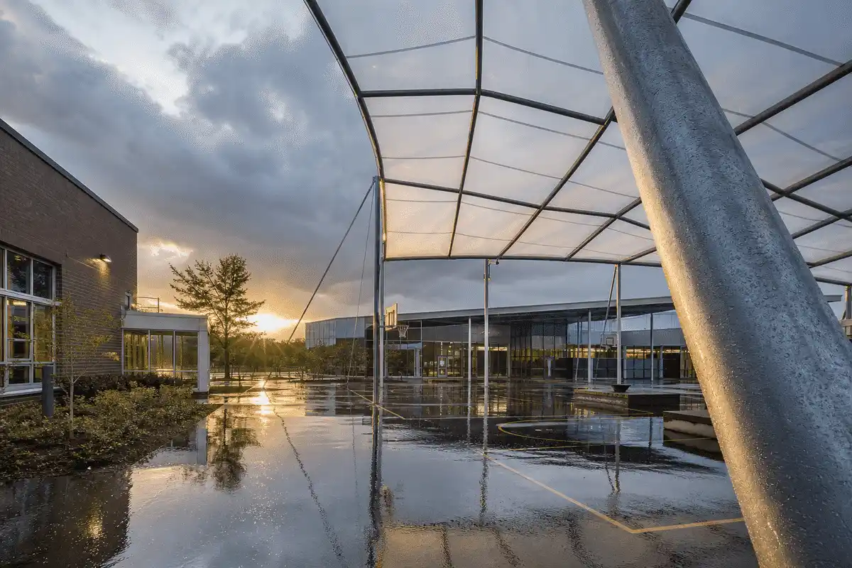 ETFE roof on a school assembly hall under dramatic storm lighting and rain — School ETFE Roofing systems