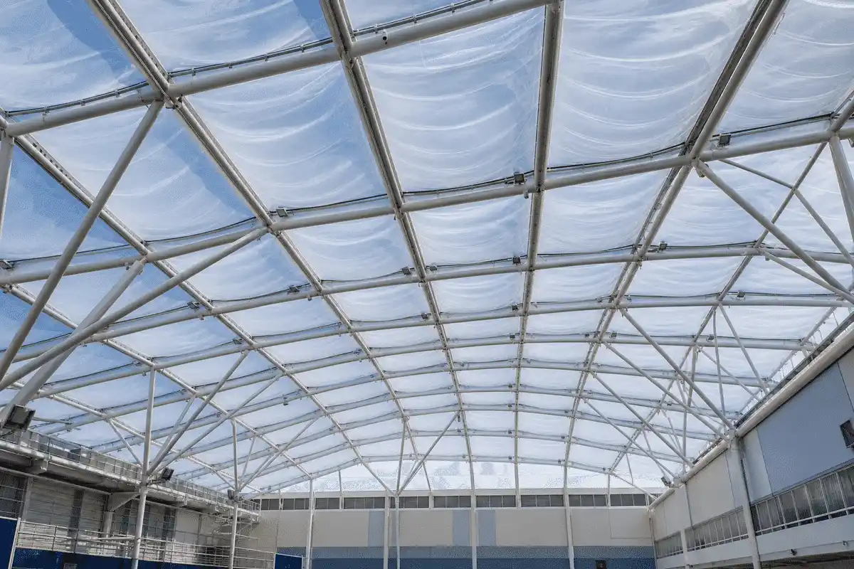 Interior looking up at a daylit ETFE cushion roof in a modern sports complex with ETFE roof