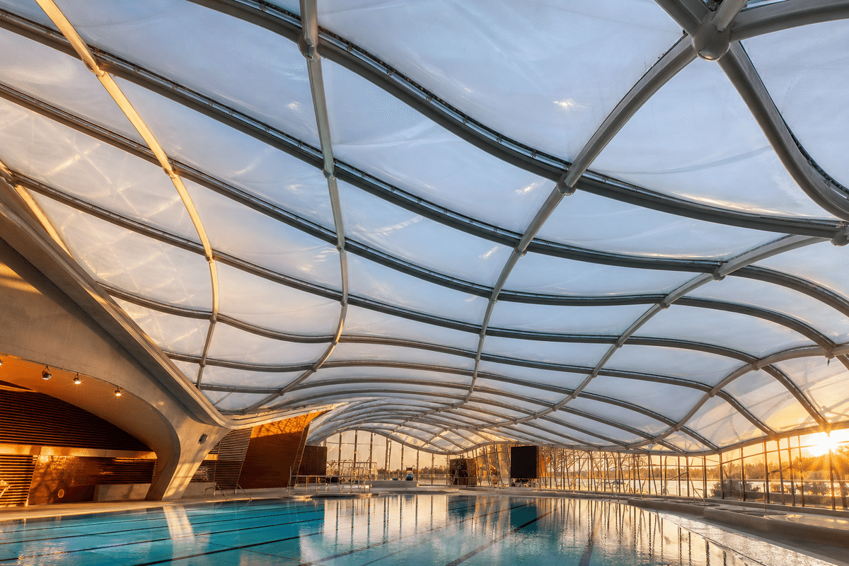 Freeform curved ETFE cushion field on a swimming pool roof