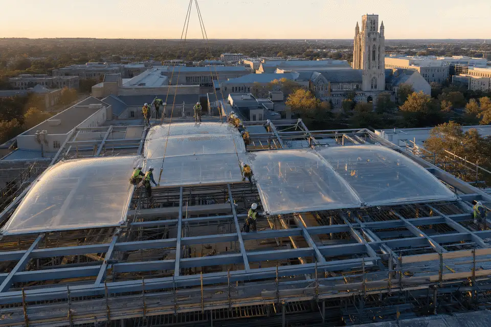 Construction crew installing ETFE modules on roof grid — University ETFE Roofing