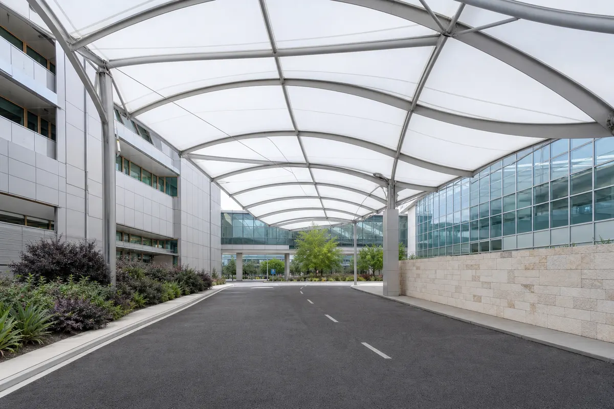 Transparent ETFE canopy sheltering a building entrance with daylight passing through the membrane