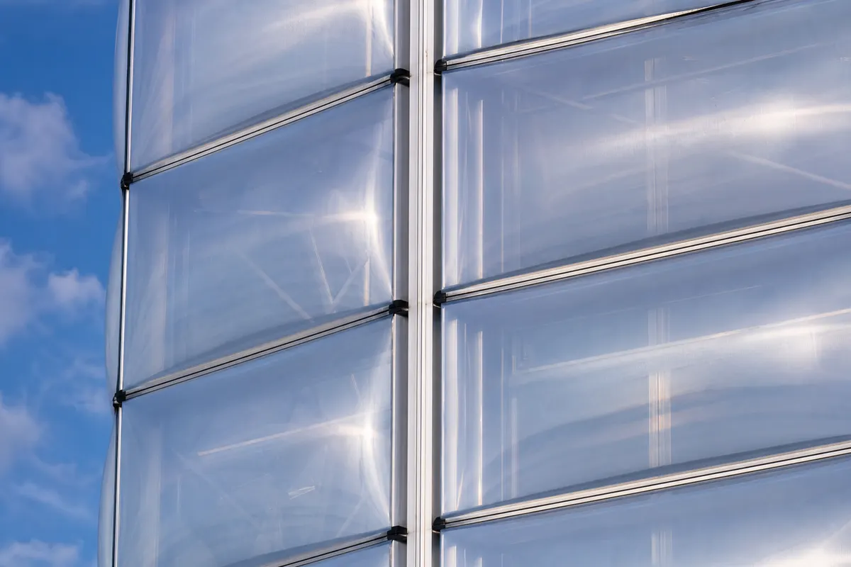 Luminous ETFE façade envelope on an institutional building at night