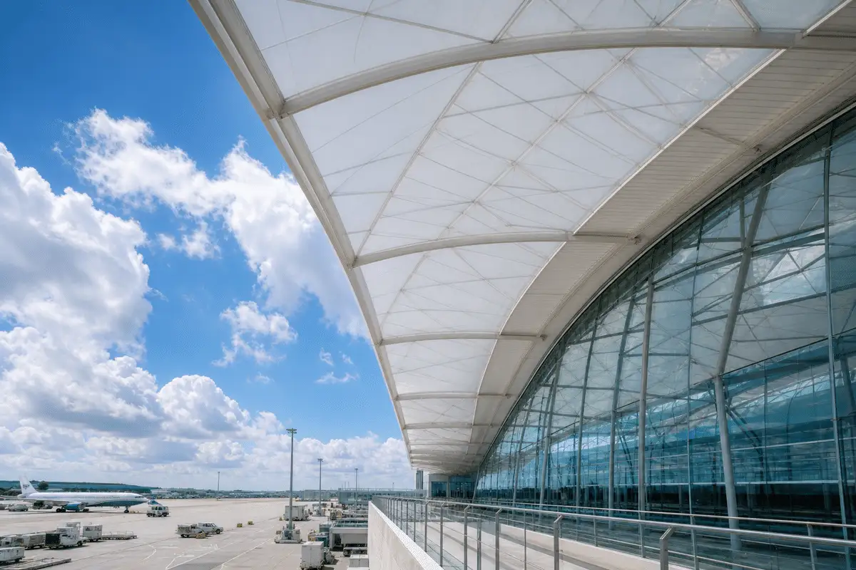 Airport terminal ETFE canopy beside glass facade section — ETFE technical guide — ETFE technical guide