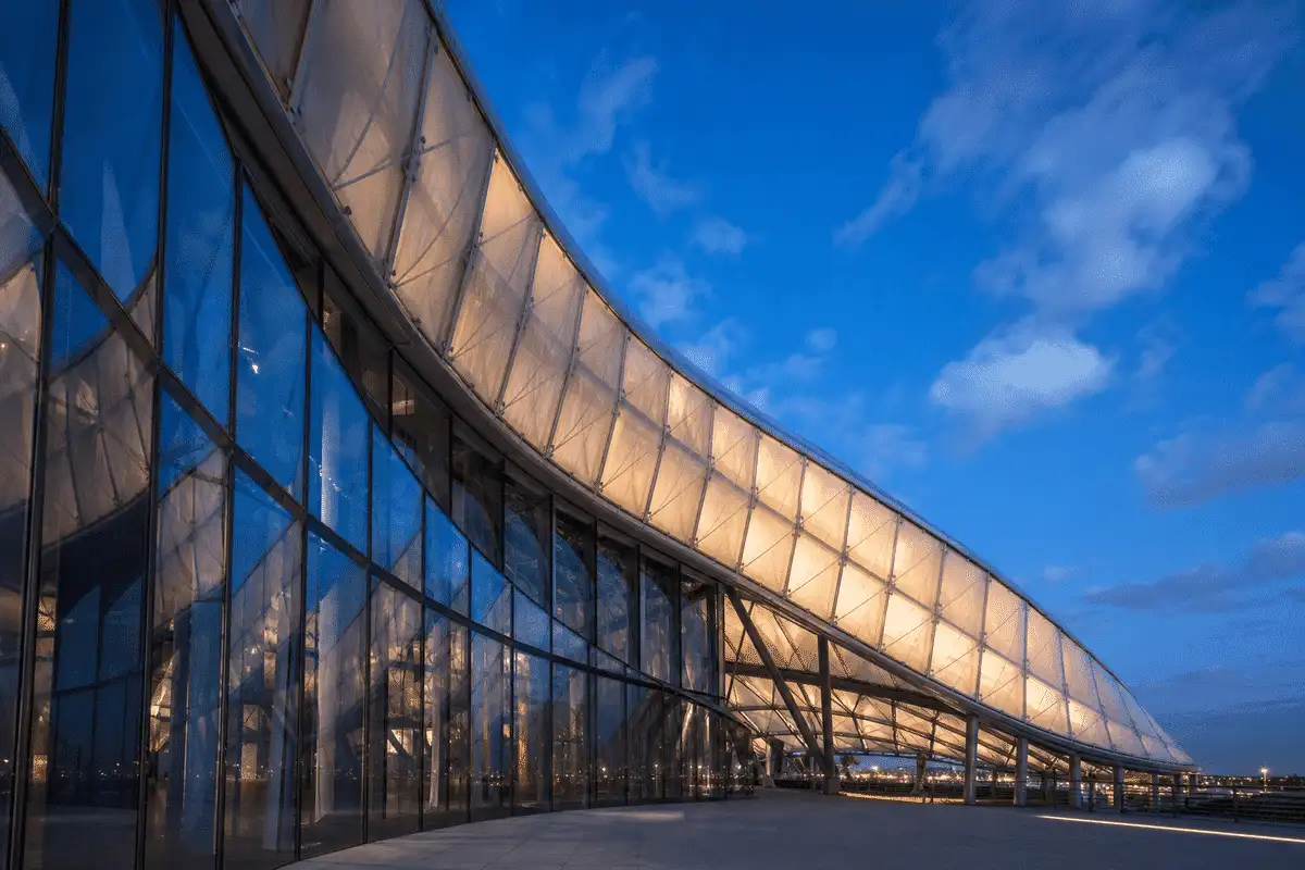Cultural center ETFE roof beside reflective glass tower — ETFE technical guide — ETFE technical guide